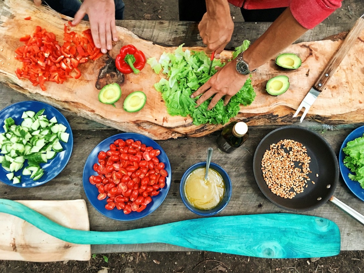Hands preparing fresh vegetables and salad ingredients